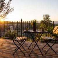 Rustic wooden cabin interior with panoramic windows overlooking scenic mountain landscape, featuring modern rustic furnishings and warm natural lighting at Scenset Mountain Ranch