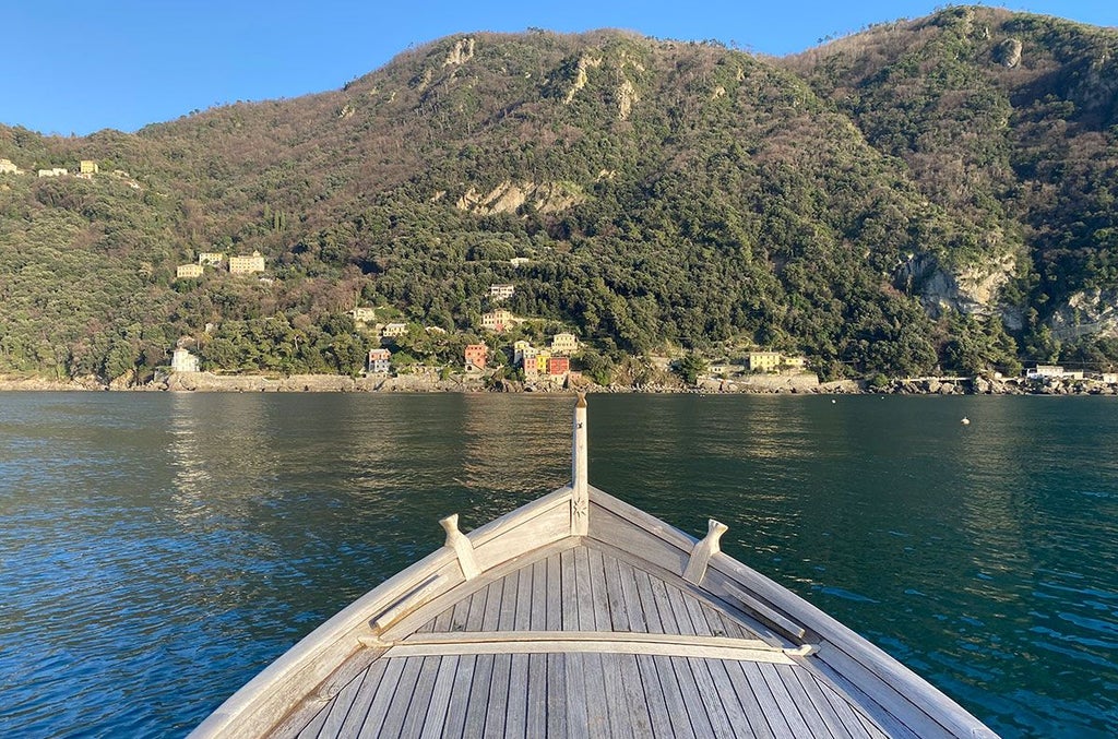 Elegant stone boutique hotel nestled in Ligurian hills, surrounded by lush rosemary gardens, with terracotta roof and panoramic coastal views of Italian riviera