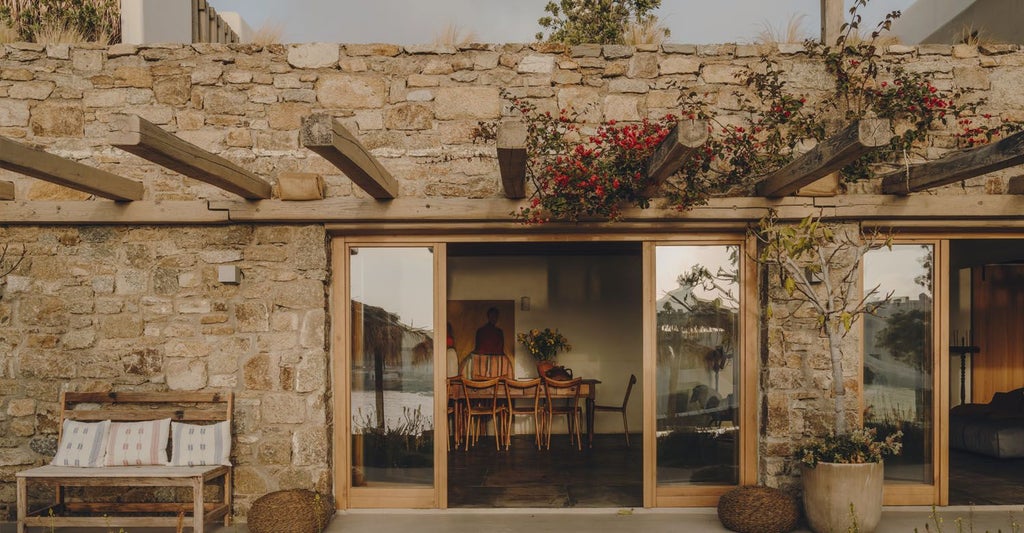 Luxurious minimalist Greek hotel with white-washed walls, infinity pool overlooking azure Aegean Sea, and sleek modern Mediterranean architecture