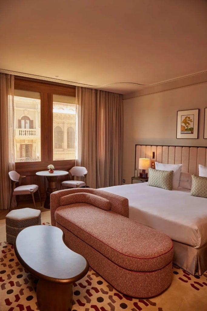 Elegant superior room at Grand Hotel Central, featuring plush white bedding, modern minimalist design, and panoramic city view in Barcelona's heart