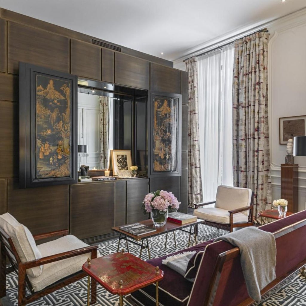 Elegant Parisian hotel interior with plush white furnishings, marble fireplace, and soft neutral tones showcasing refined luxury design in central Paris