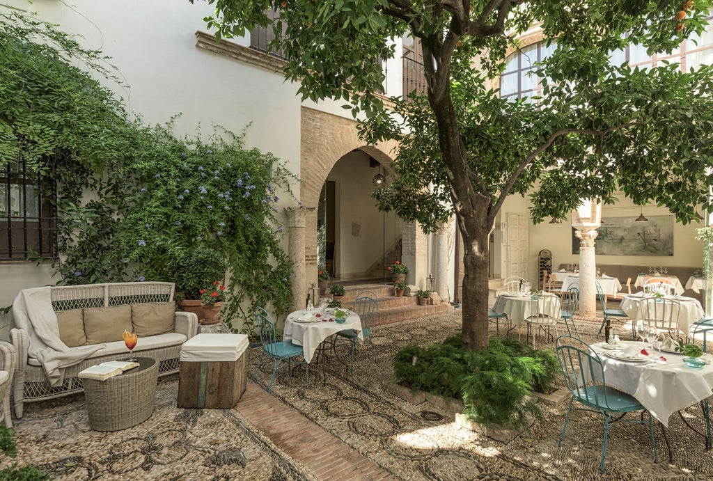 Elegant colonial-style hotel with white-washed walls, intricate wooden balconies overlooking historic Córdoba's charming streets and traditional Andalusian architecture