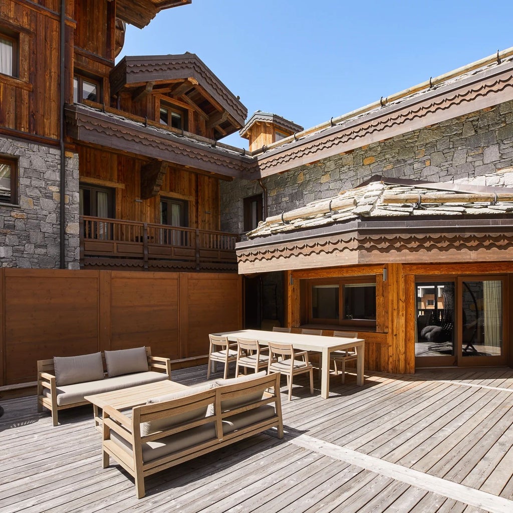 Luxurious alpine ski resort with modern chalet-style architecture, snow-covered peaks, and elegant exterior showcasing Six Senses mountain retreat in Courchevel