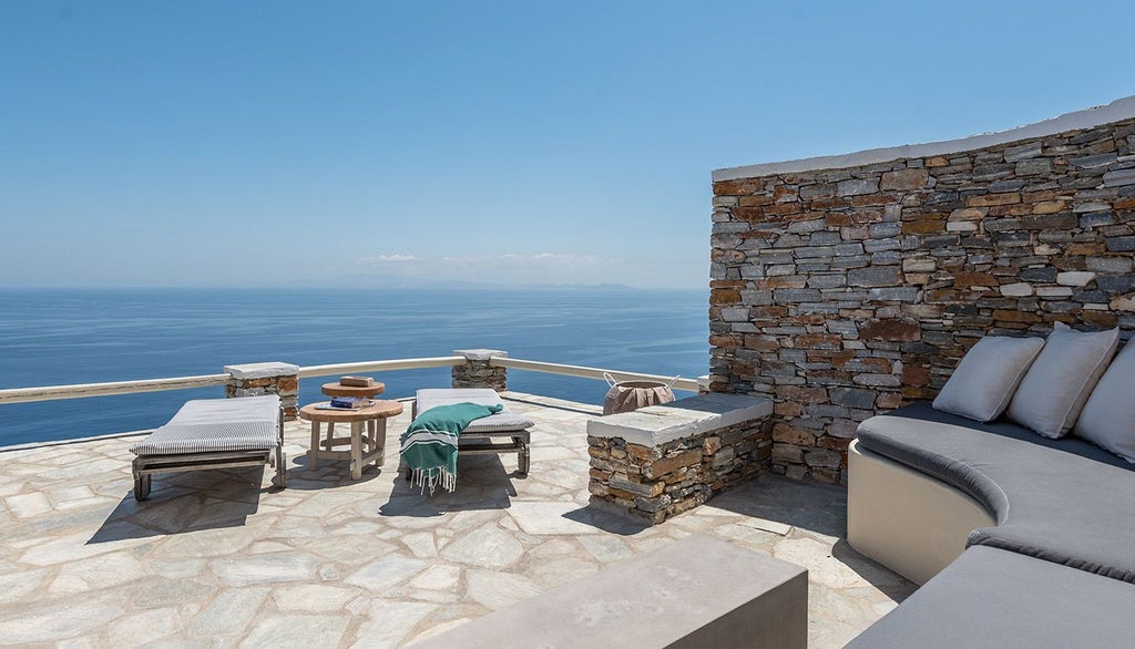 Luxurious minimalist hotel room with white linens, clean design, and panoramic Aegean Sea view from Verina Astra in Sifnos, Greece