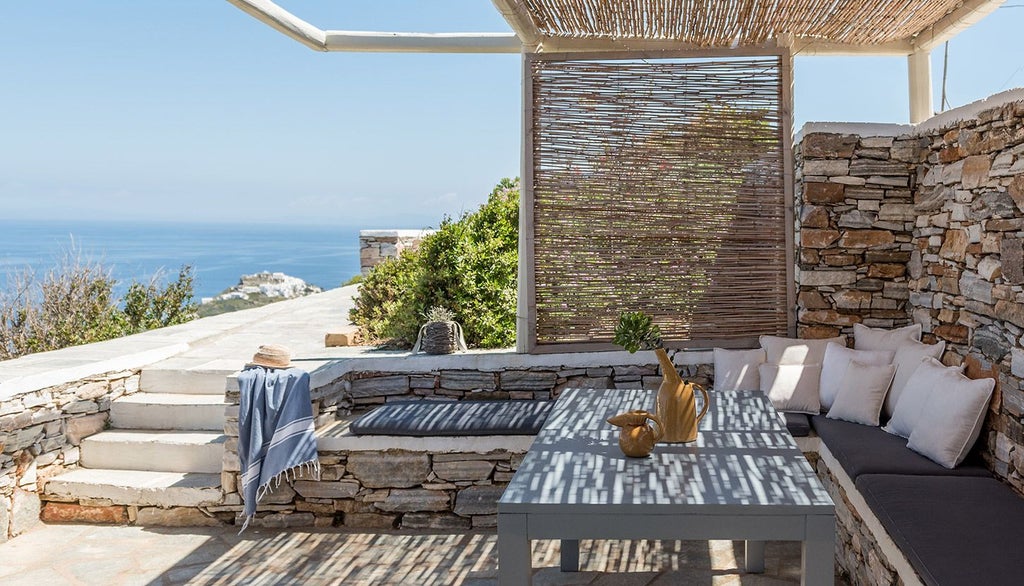 Minimalist white-washed Cycladic hotel room with panoramic Aegean Sea view, sleek design, private balcony, and elegant contemporary Greek island aesthetic