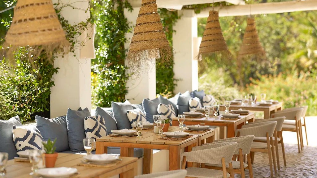 Luxurious whitewashed villa with terracotta roofs nestled in Algarve landscape, surrounded by lush gardens and traditional Portuguese architectural elements