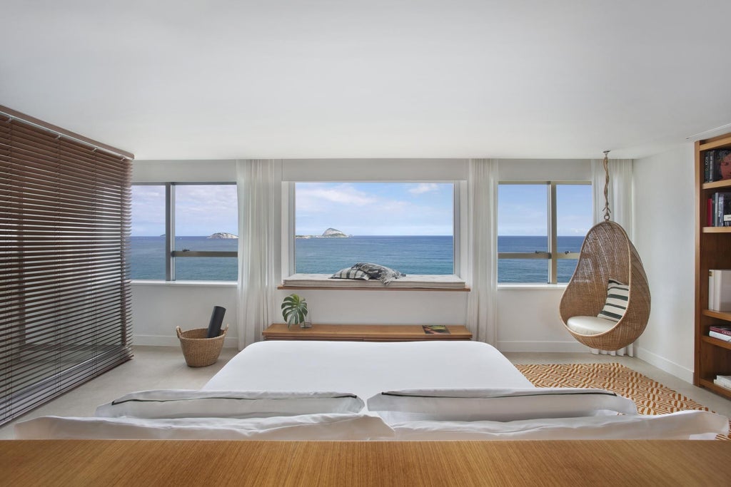 Luxurious modern hotel room at Janeiro Hotel with minimalist design, ocean views, and sleek wooden furniture overlooking scenic Brazilian coastline