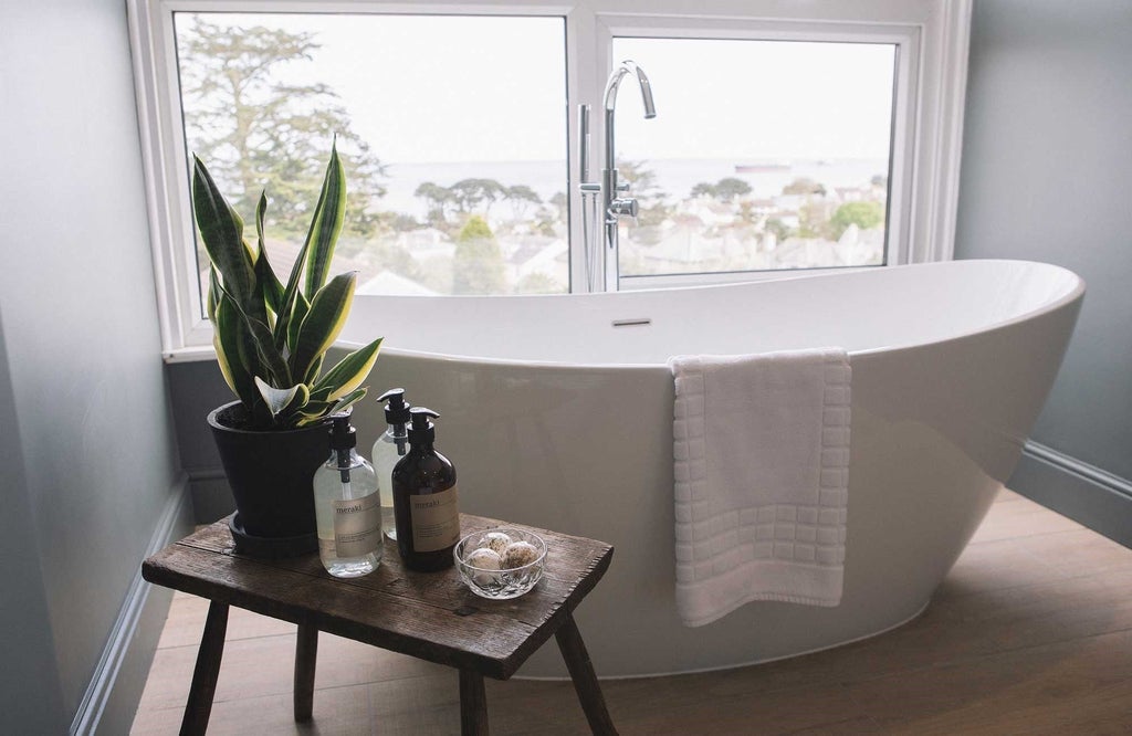 Elegant coastal-themed hotel bedroom with crisp white linens, ocean-inspired decor, plush bedding, and serene neutral tones reflecting UK seaside sophistication