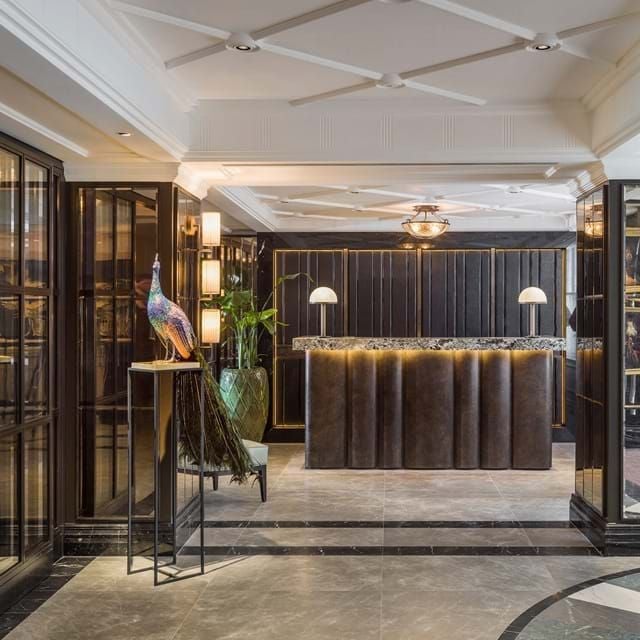 Elegant boutique hotel exterior in London's Mayfair, featuring Georgian architecture, modern luxury facade with soft lighting and refined architectural details.