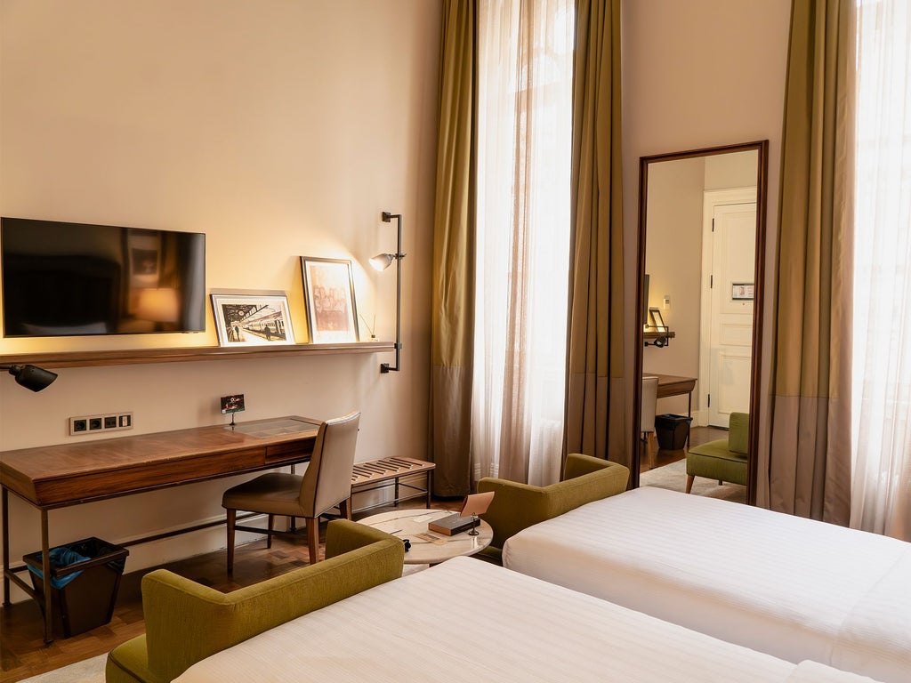 Luxurious twin hotel room with elegant decor, plush beds, large windows overlooking Istanbul's historic landscape in a converted bank building