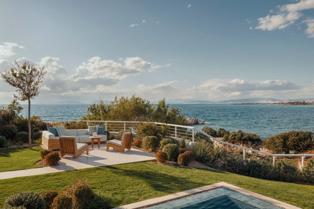 Luxurious Villa Kyma bedroom with minimalist white curved architecture, panoramic Aegean Sea view, and elegant contemporary Mediterranean design.