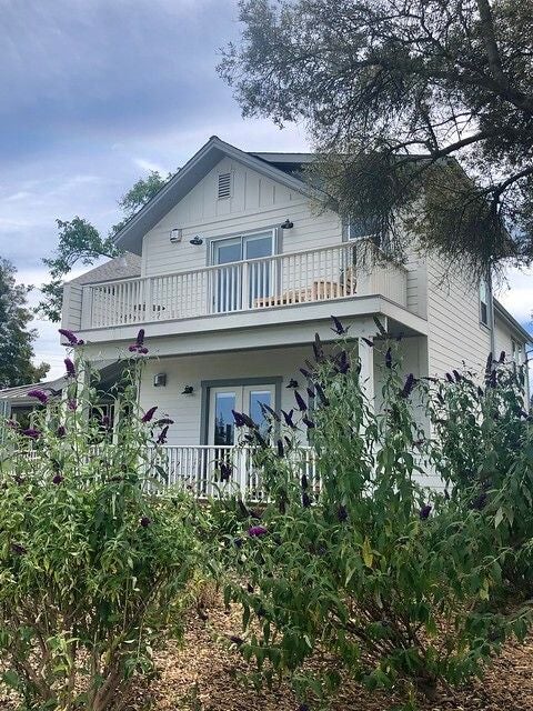 Historic boutique hotel with luxurious white exterior, elegant columns, and manicured gardens surrounded by towering redwood trees