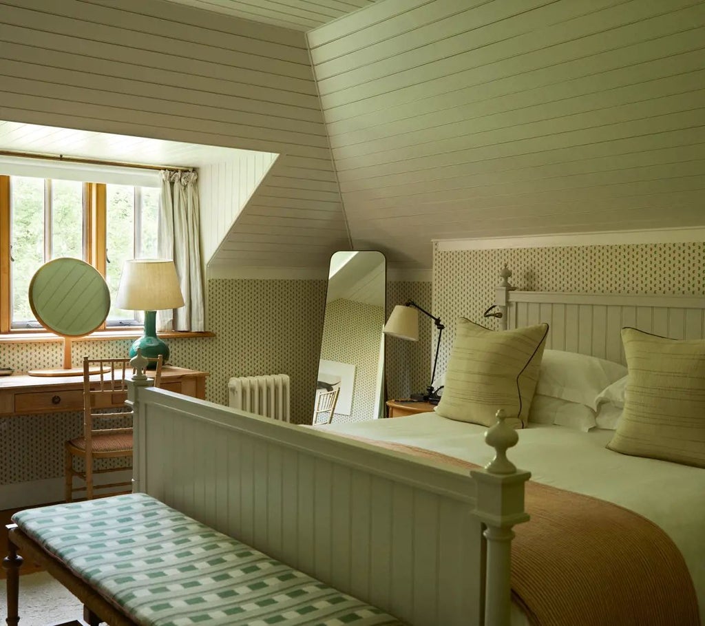 Luxurious forest hideaway suite with natural wood paneling, plush king bed, and floor-to-ceiling windows overlooking lush woodland scenery at Lime Wood Hotel