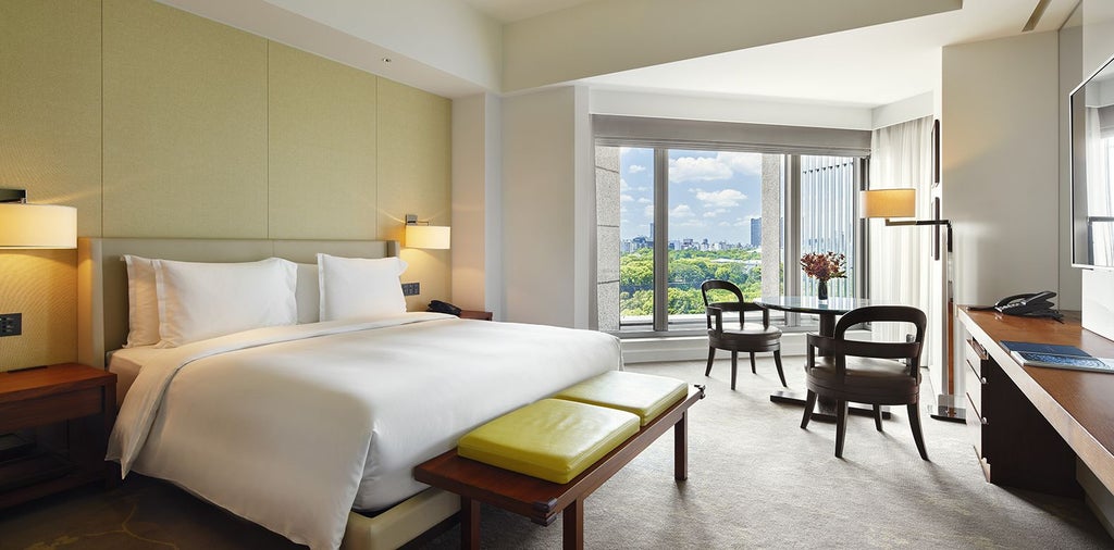 Elegant deluxe king hotel room with panoramic views of Tokyo's inner moat, featuring modern Japanese design, plush bedding, and sophisticated city landscape