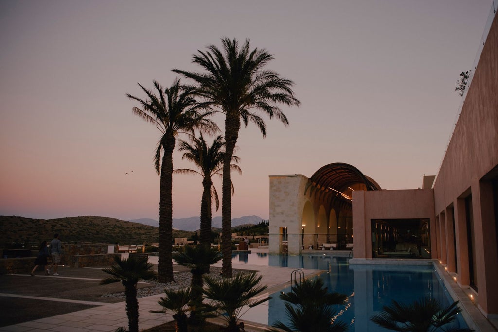 Luxurious infinity pool overlooking Aegean Sea at Blue Palace resort, with white sun loungers and traditional Greek architecture