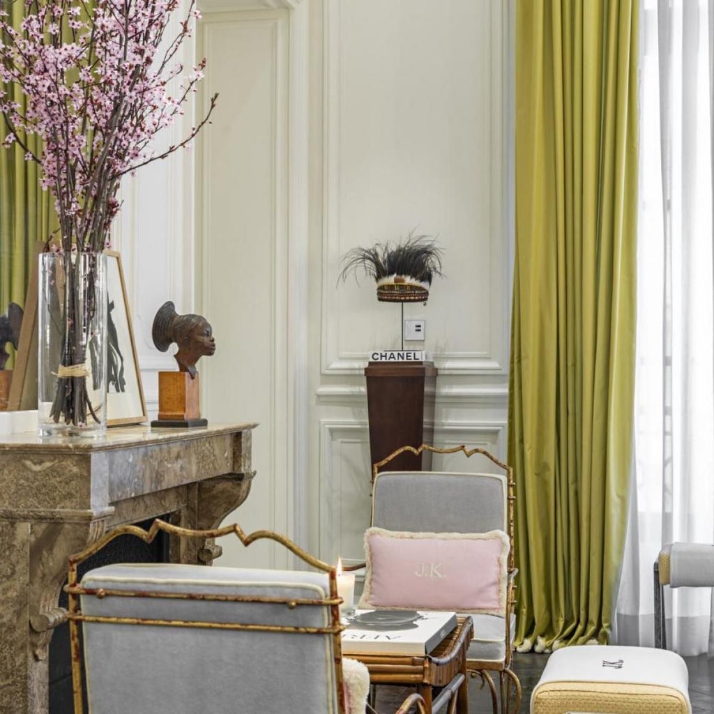 Elegant Parisian hotel interior with plush white sofas, marble fireplace, and sophisticated neutral color palette showcasing French luxury design