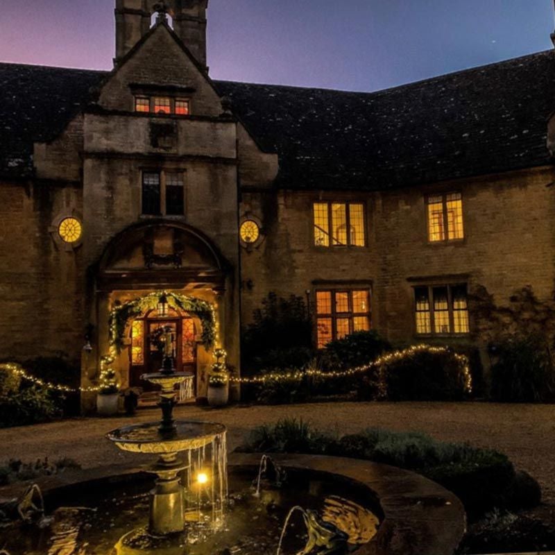 Luxurious chestnut-toned bedroom with plush bedding, elegant furnishings, and soft natural light in a refined UK countryside manor setting.