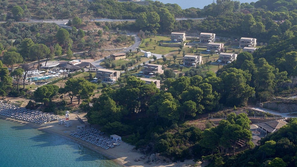 Luxurious poolside view of boutique hotel with infinity pool overlooking azure Aegean Sea, white sunbeds, and modern Greek architectural design in Skiathos