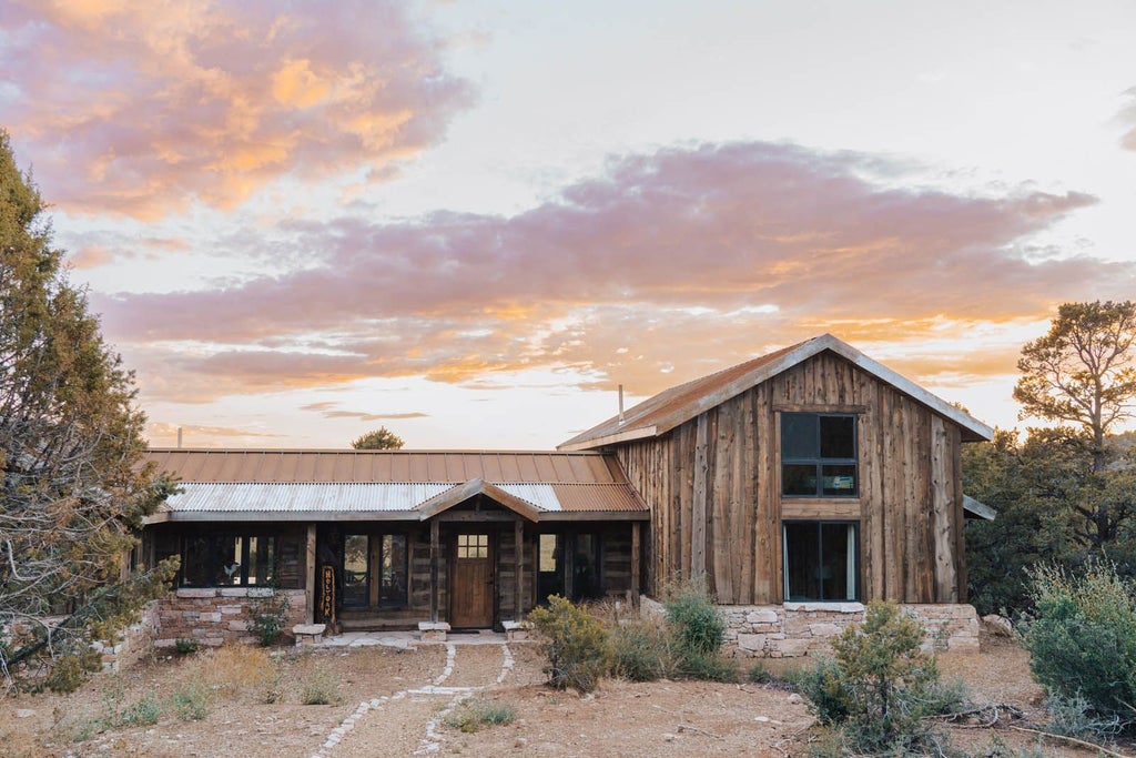 Rustic lodge room with wooden furnishings, plush bedding, and panoramic mountain views at Scenset Mountain Ranch in the United States.