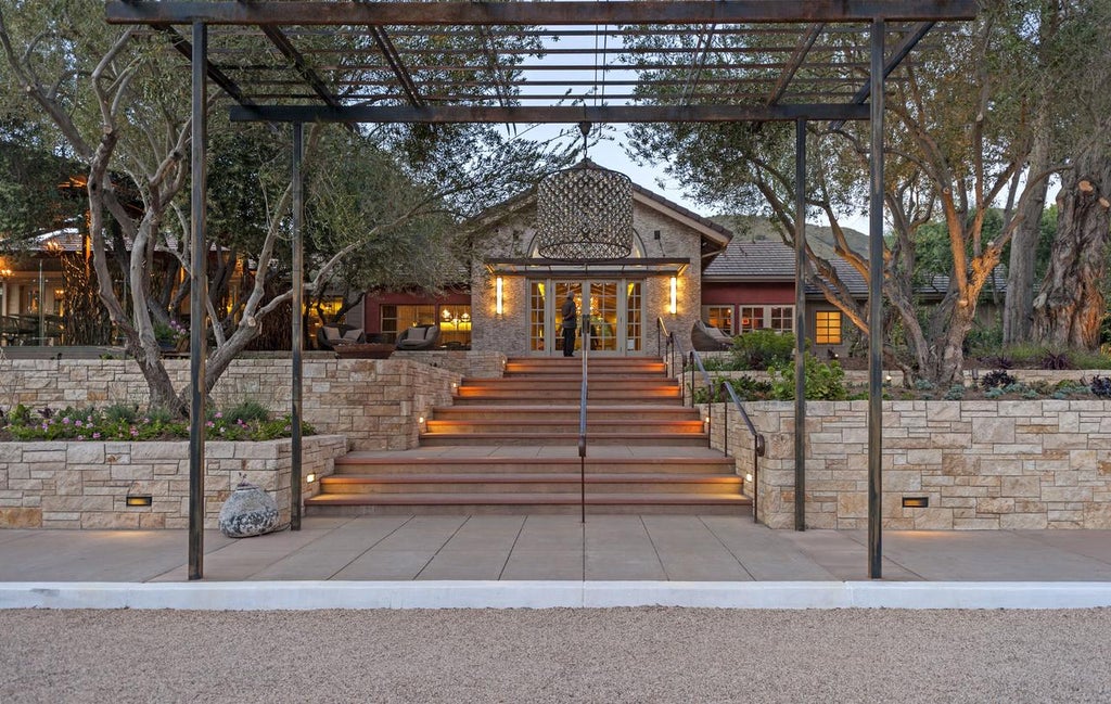 Luxurious stone villa resort nestled in California wine country, featuring manicured gardens, elegant archways and mountain backdrop