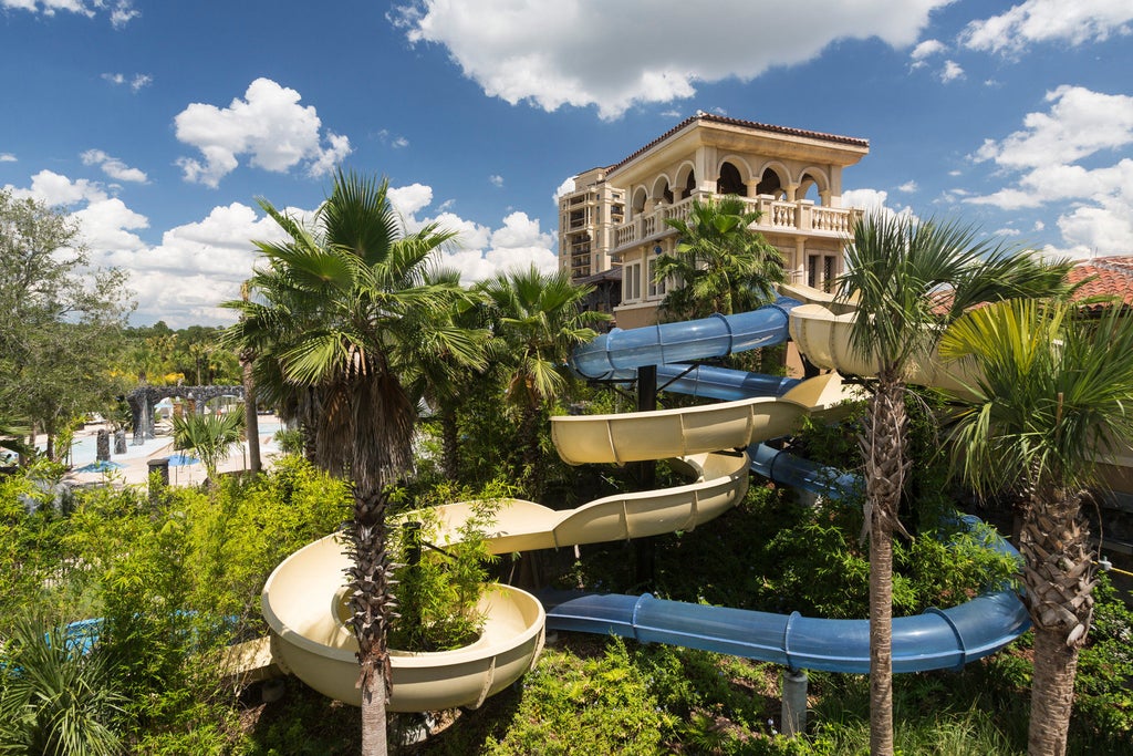 Luxurious resort tower of Four Seasons Orlando with Mediterranean-style architecture, palm trees, and pristine landscaped gardens at dusk