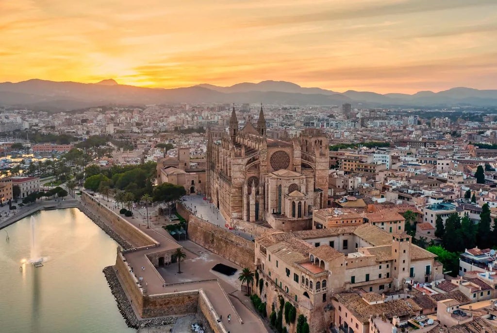 Historic Spanish luxury hotel with stone facade, arched windows, and elegant colonial architecture nestled in a serene urban setting in Palma de Mallorca