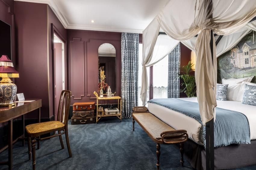 Elegant Parisian hotel room with plush bedding, vintage decor, and soft neutral tones in warm browns and creams, showcasing refined French hospitality