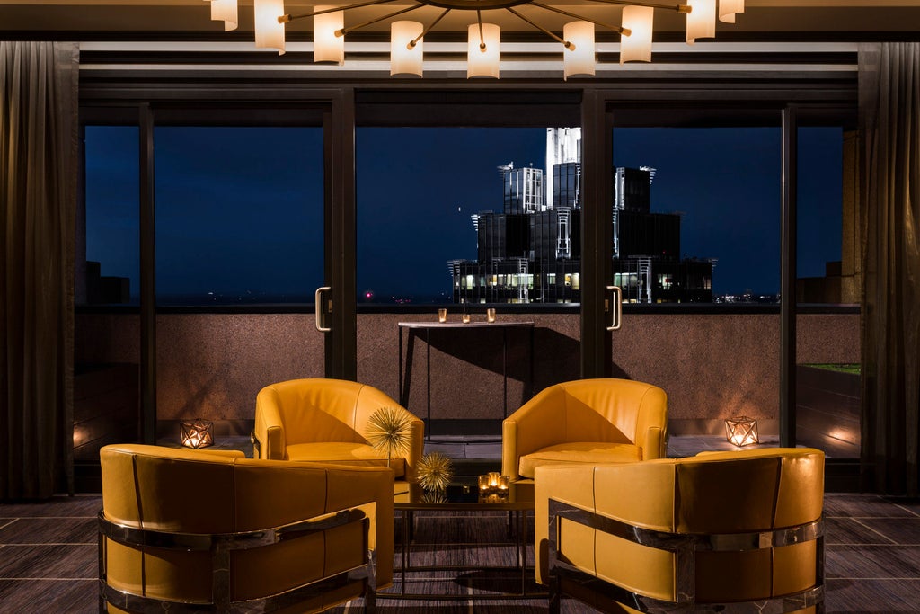 Elegant high-rise hotel with glass facade in downtown Atlanta, illuminated against evening sky, featuring modern architecture and luxury entrance