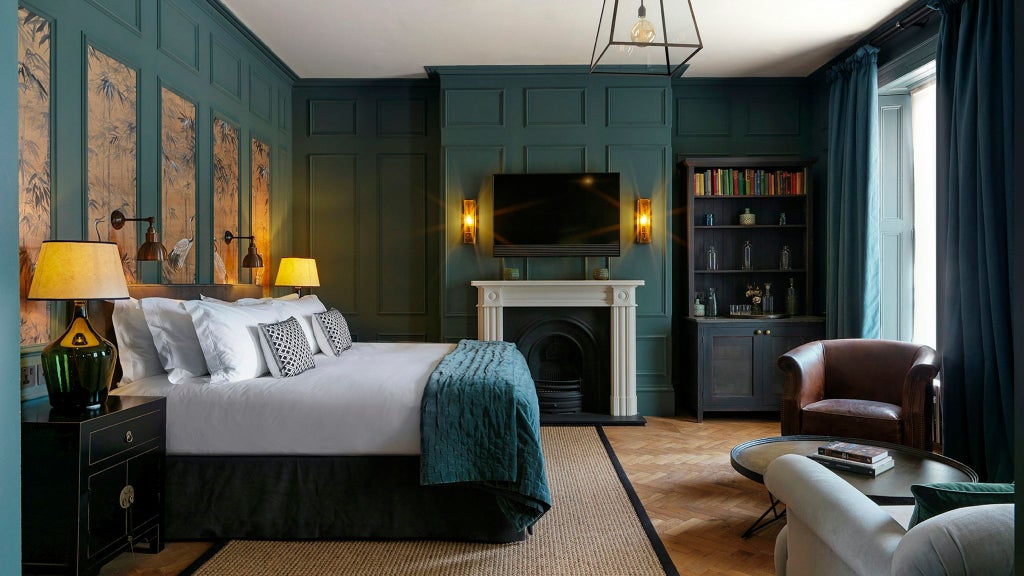 Elegant UK boutique hotel room with plush king bed, soft neutral decor, contemporary furniture, and warm ambient lighting creating luxurious sanctuary