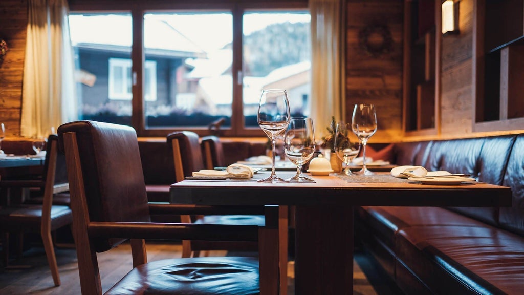 Luxurious alpine chalet-style hotel nestled in Swiss mountains, featuring wooden facade, snow-capped peaks, and elegant minimalist mountain design