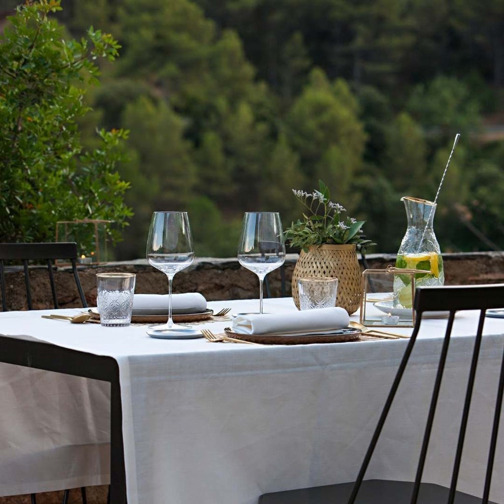 Luxurious Spanish winery hotel nestled among rolling vineyards, featuring elegant stone architecture with terracotta roofs and panoramic mountain views