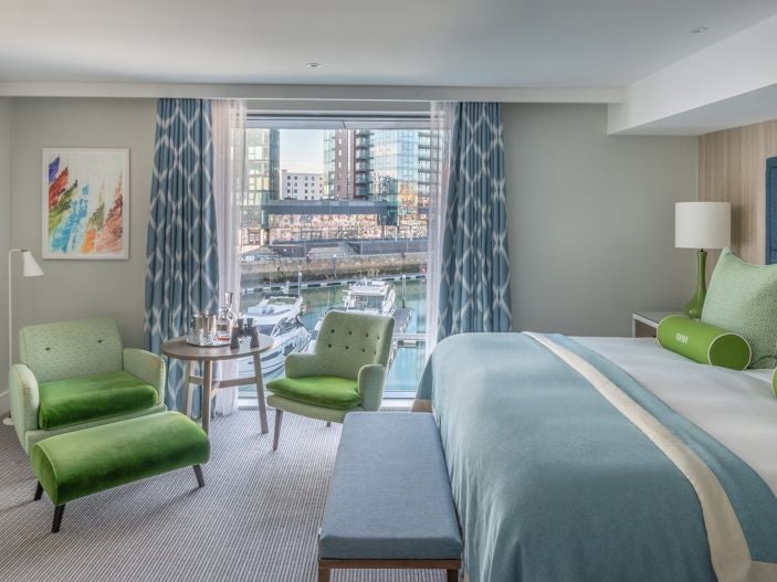 Spacious accessible hotel room with modern amenities, wide doorways, roll-in shower, and elegant nautical-inspired decor overlooking Southampton's harbour scenery