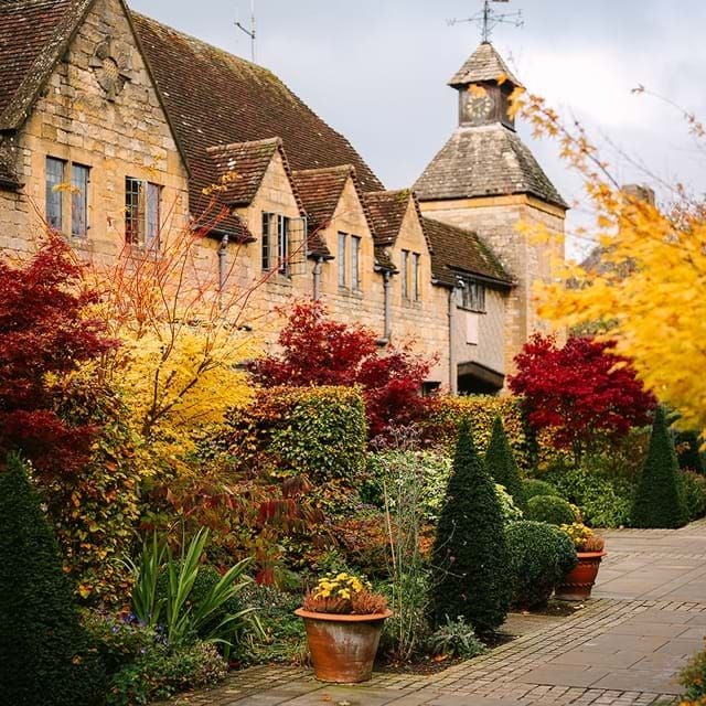 Elegant Tudor-style luxury hotel with stone facade, manicured gardens, and historic charm nestled in the scenic Cotswolds countryside of United Kingdom