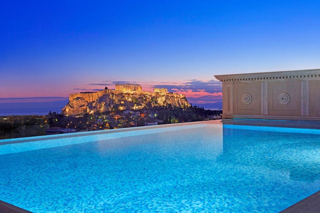 Historic elegance meets luxury at this six-floor hotel in Athens, featuring ornate columns, classic architecture, and a grand entrance facade