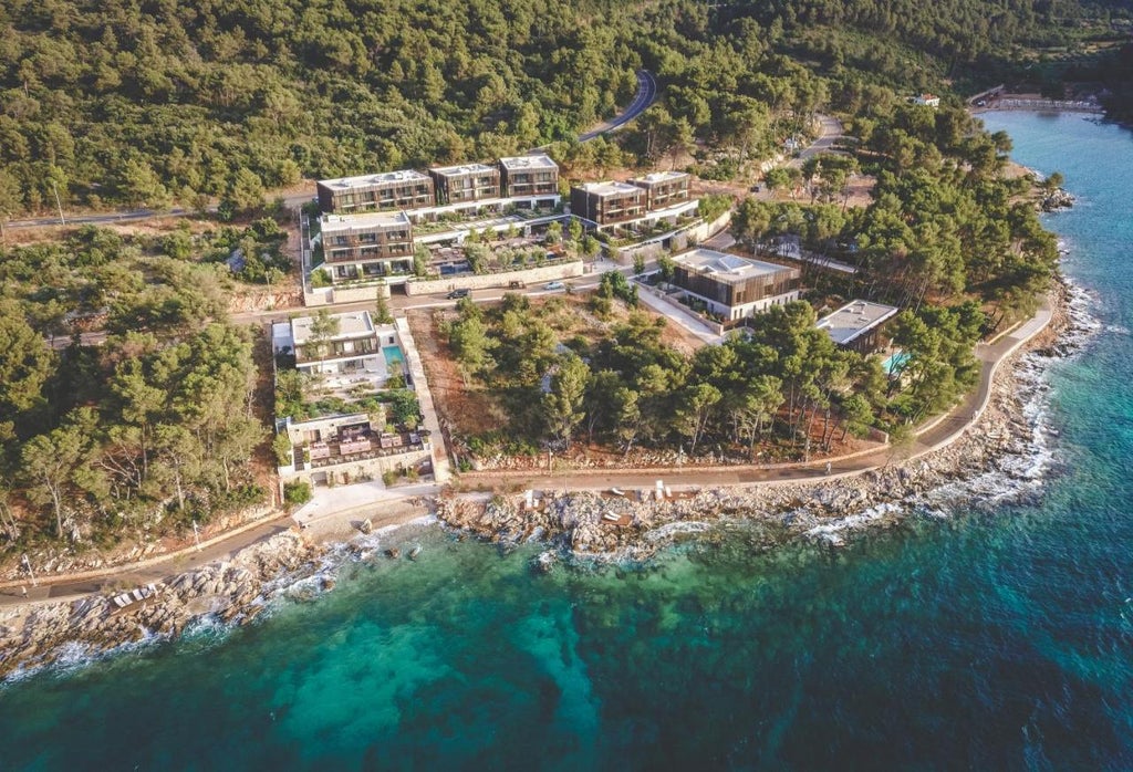 Modern beachfront resort with sleek infinity pool overlooking Adriatic Sea, surrounded by olive trees and Mediterranean gardens at sunset