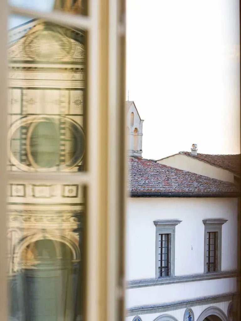 Elegant boutique hotel exterior in Florence with arched windows, stone facade, decorative shutters and classic Italian architectural details