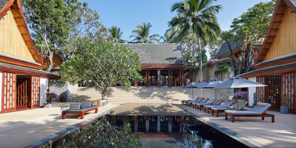 Luxurious six-bedroom villa with infinity pool overlooking tropical gardens, featuring contemporary Thai architecture and outdoor loungers