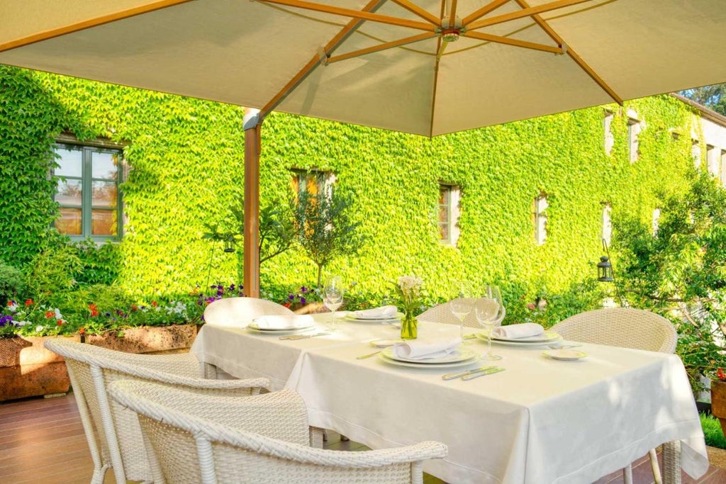 Historic Spanish luxury hotel with stone facade, featuring manicured gardens, traditional architecture, and elegant window details