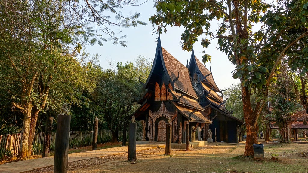 Scenic Thailand landscape with sleek mountain bikes, traditional longtail boats, picturesque rural villages, and mystical limestone cave entrances under golden sunlight