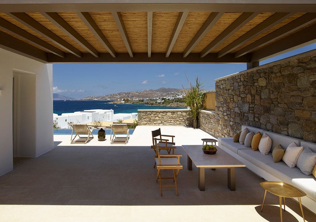 Luxurious bedroom with private heated pool overlooking the Aegean Sea, featuring modern design and panoramic views of scenic Mykonos, Greece