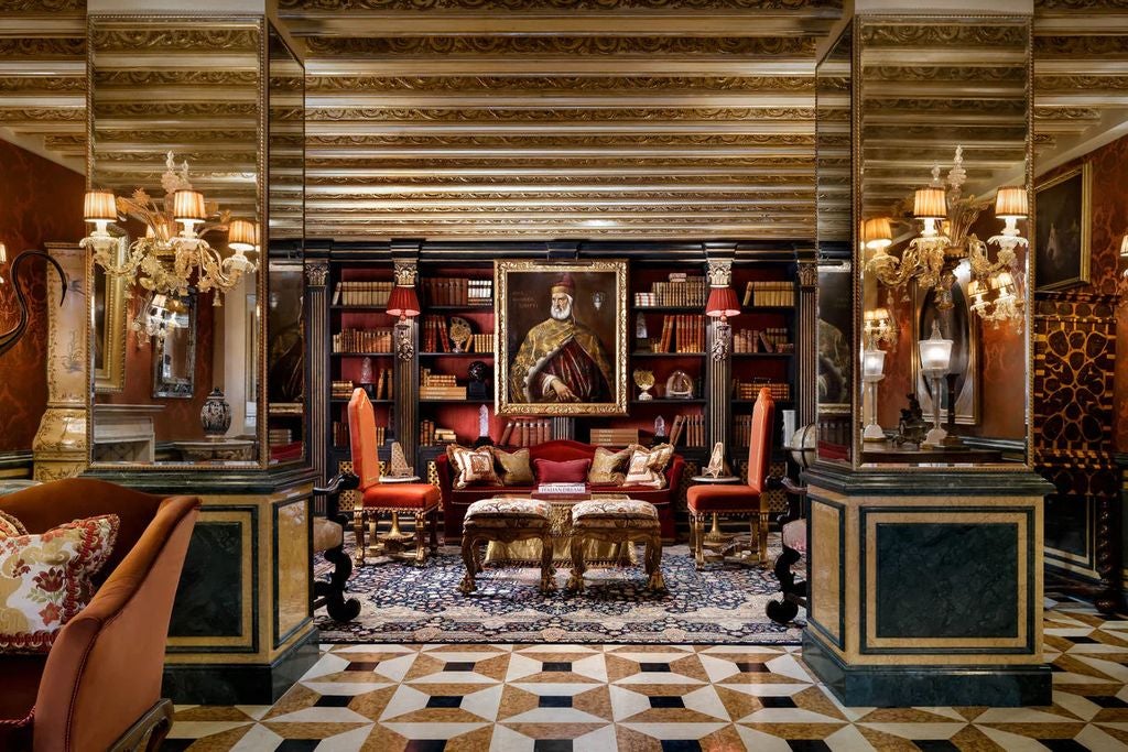 Elegant Renaissance-style Gritti Palace hotel on Venice's Grand Canal with ornate marble facade, Gothic windows and classic gondolas below