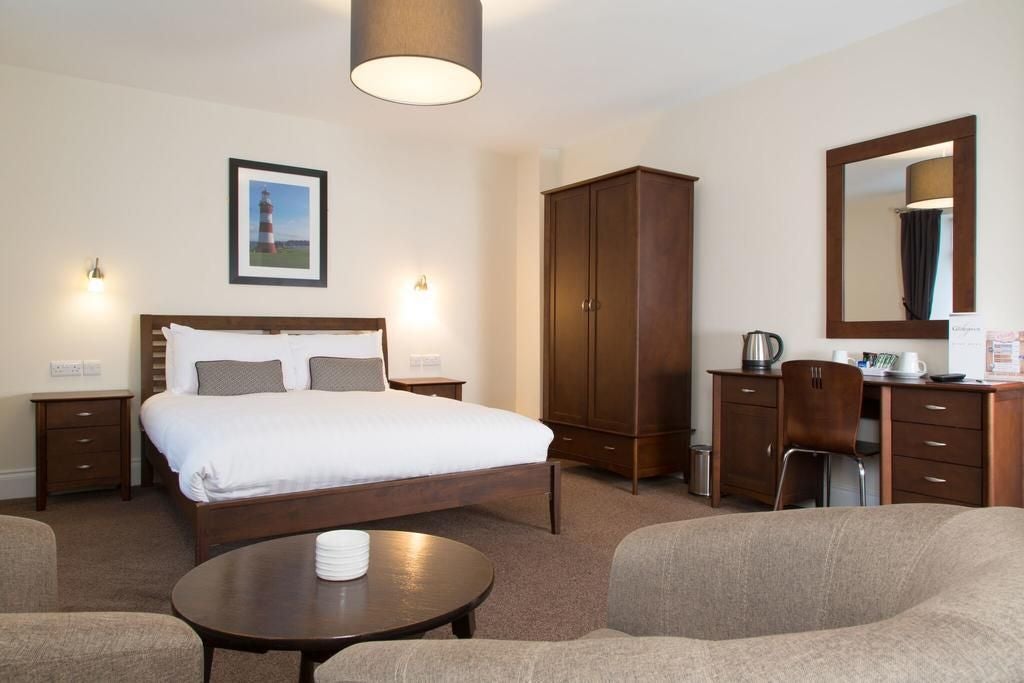 Elegantly appointed superior double room at scenset hotel with plush bedding, contemporary decor, large windows, and sophisticated neutral color palette