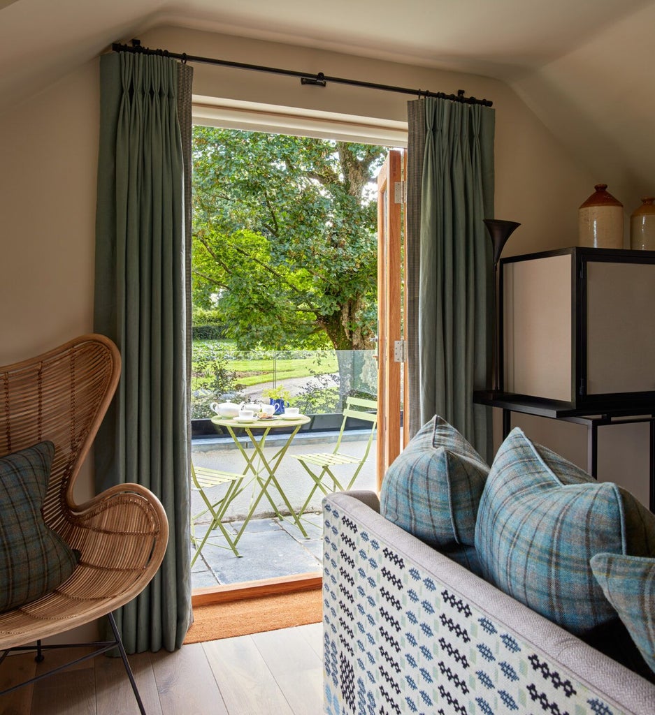 Elegant hotel room with soft neutral tones, plush bedding, and intricate wooden furniture at Grove of Narberth's Lovage suite, showcasing refined countryside charm.