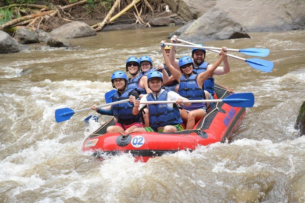 White water rafting adventure on Ayung River, Bali, with professional guides navigating rapids amid lush tropical rainforest scenery