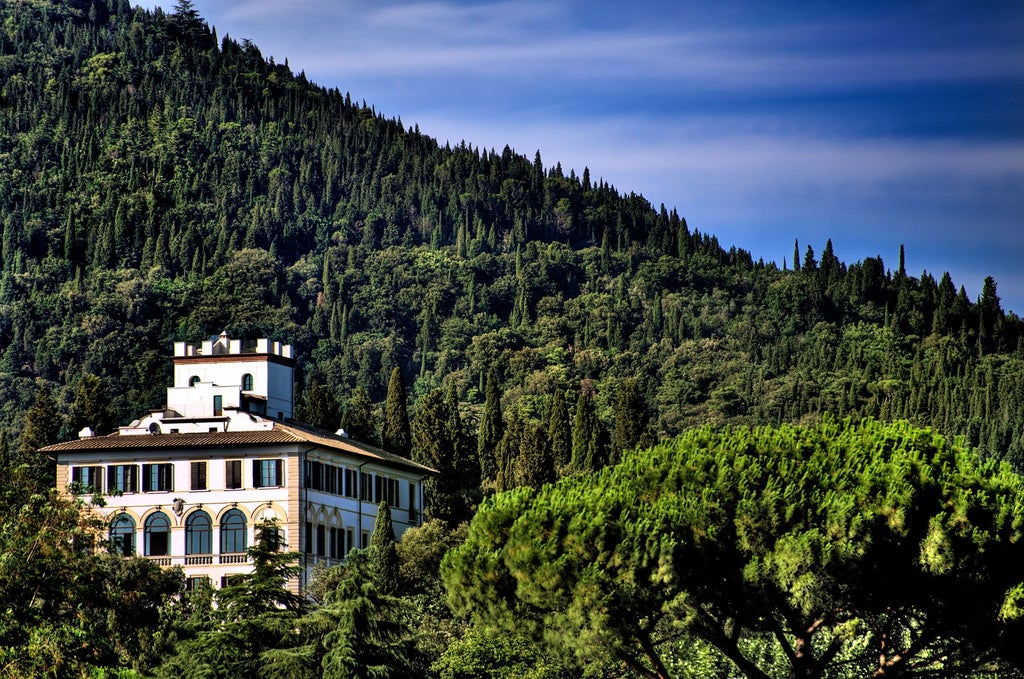 Ornate Renaissance hotel Il Salviatino set on Tuscan hillside, featuring elegant terraces, manicured gardens and panoramic Florence views.