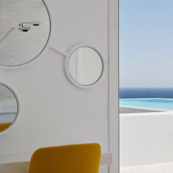 Luxurious white minimalist hotel room with panoramic Aegean Sea view, private infinity pool, and elegant contemporary Cycladic design at scenset Ambassador Hotel.