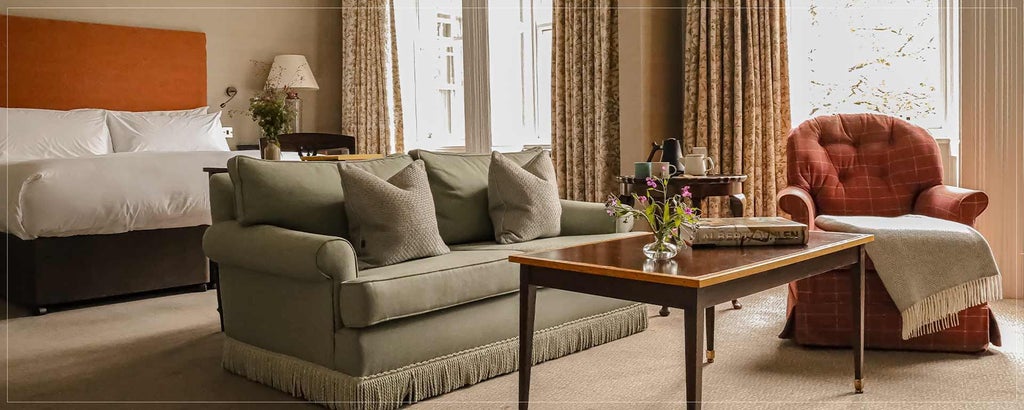 Elegant king suite with panoramic window overlooking lush Irish landscape, featuring plush white bedding and contemporary coastal-inspired decor at a premium hotel