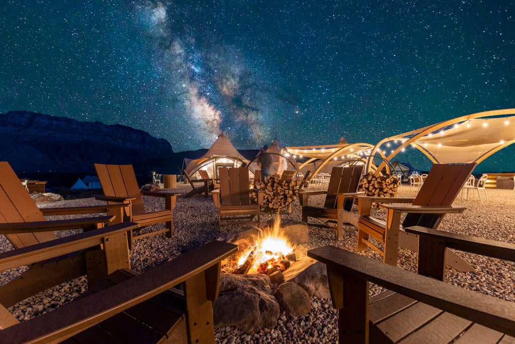 Luxurious safari-style glamping tent nestled in rugged desert landscape with red rock formations of Zion National Park in background