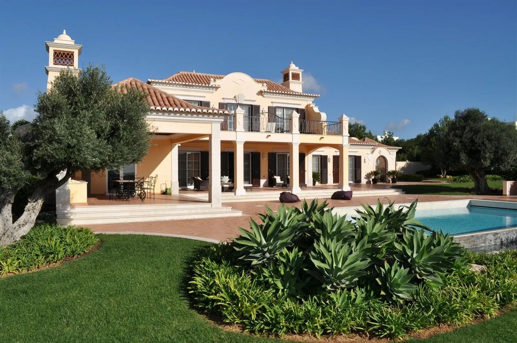 Luxurious white-walled villa with modern minimalist design, spacious terrace overlooking turquoise ocean, contemporary beach-style furnishings, Sagres coastal landscape