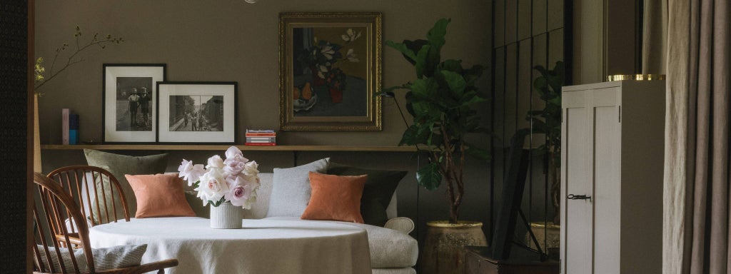 Elegant master bedroom at Heckfield Place with soft neutral tones, plush king-sized bed, expansive windows overlooking lush countryside landscape in United Kingdom